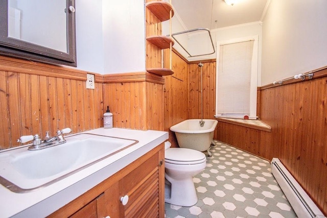 bathroom with a baseboard radiator, a wainscoted wall, wood walls, a freestanding bath, and tile patterned floors