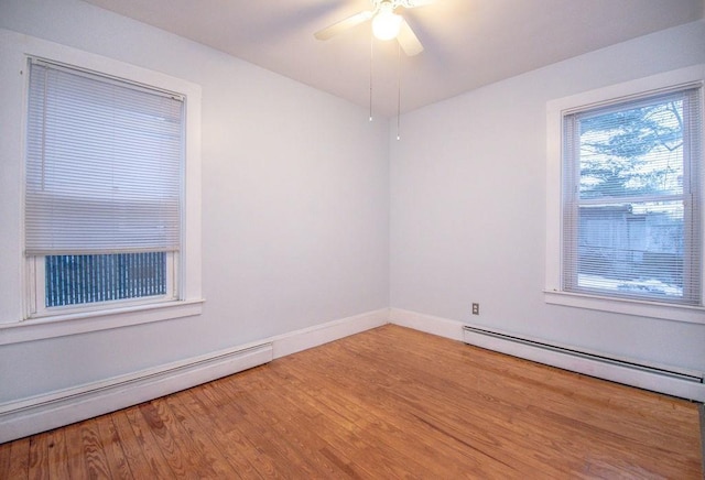 unfurnished room with a baseboard radiator, a baseboard heating unit, ceiling fan, wood finished floors, and baseboards