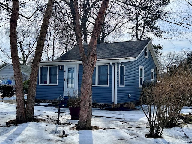 bungalow featuring roof with shingles