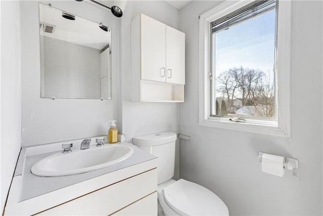 bathroom with visible vents, toilet, and vanity