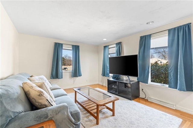 living room featuring visible vents, a healthy amount of sunlight, baseboards, and wood finished floors