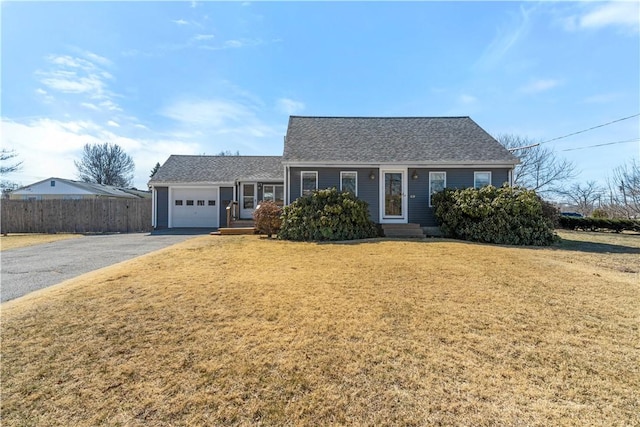 view of front of house featuring aphalt driveway, a front yard, an attached garage, and fence