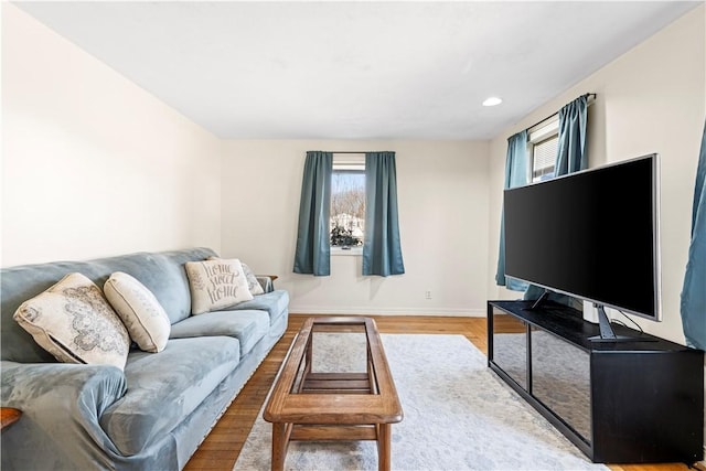 living room featuring recessed lighting, baseboards, a healthy amount of sunlight, and wood finished floors