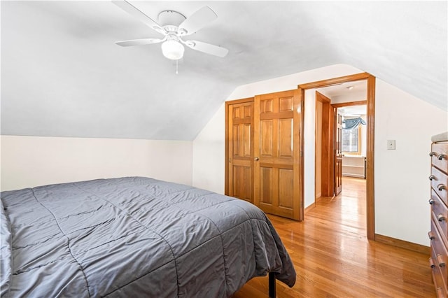 bedroom featuring vaulted ceiling, light wood-style flooring, a ceiling fan, and baseboards