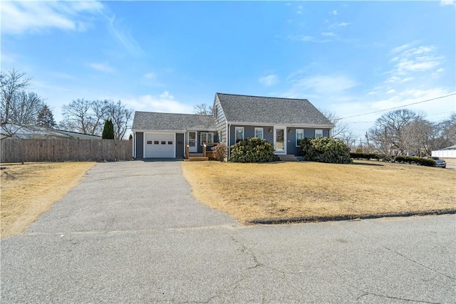 view of front of property with aphalt driveway, an attached garage, fence, and a front lawn