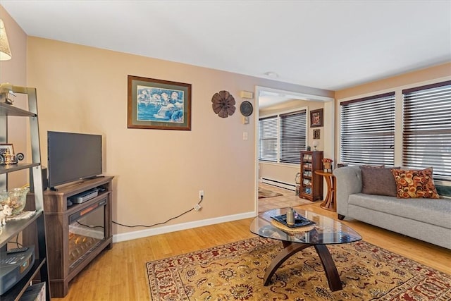 living area featuring light wood finished floors, baseboards, and baseboard heating