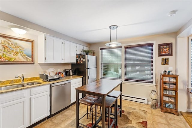 kitchen featuring a baseboard heating unit, stainless steel appliances, a sink, white cabinets, and pendant lighting