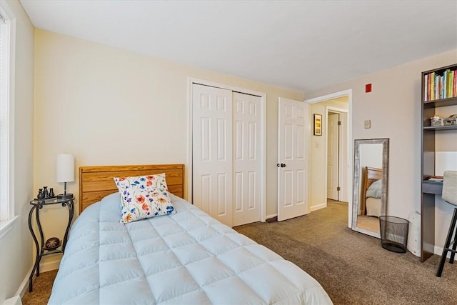 bedroom featuring dark colored carpet, a closet, and baseboards