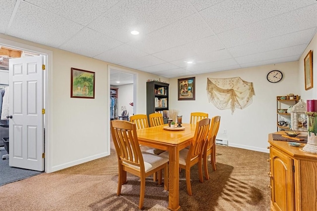 carpeted dining area with a baseboard heating unit, a drop ceiling, recessed lighting, and baseboards