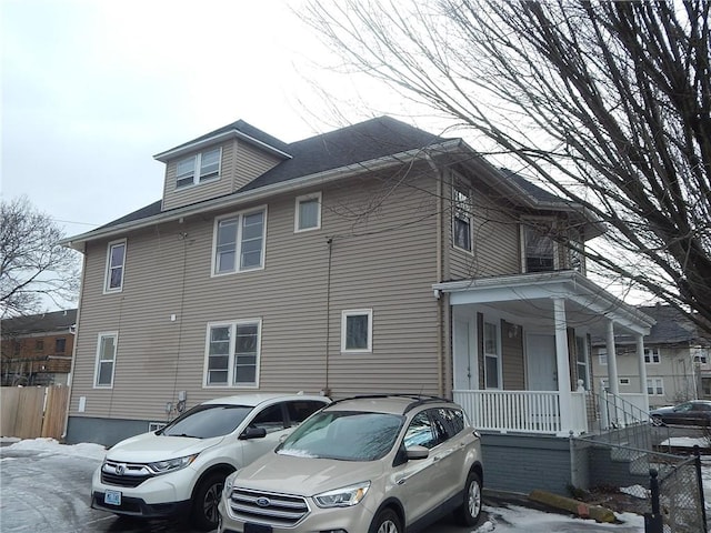 view of side of property with fence and a porch