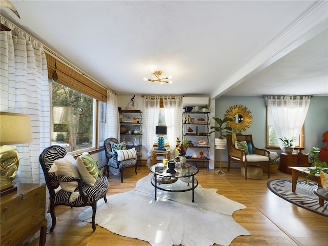 living area with light wood finished floors, a wall mounted air conditioner, and a notable chandelier