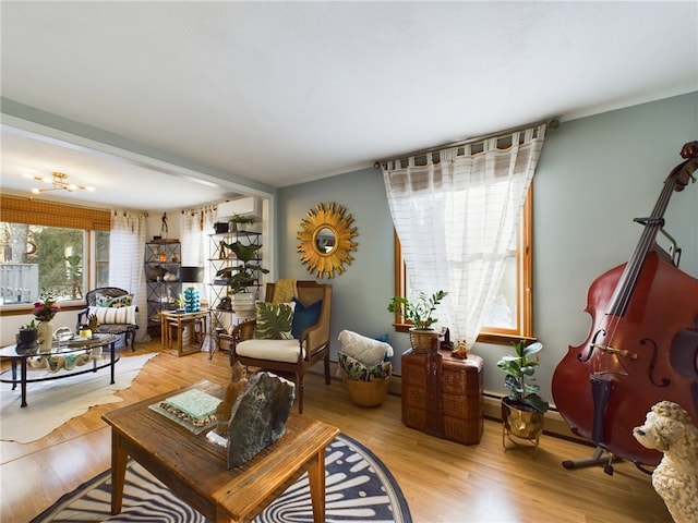 living area with light wood-type flooring and a wall mounted AC