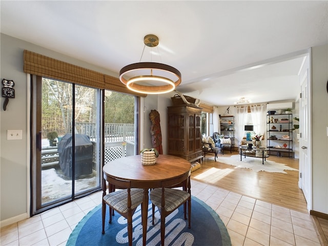 dining space with light tile patterned floors, a wall unit AC, a wealth of natural light, and baseboards