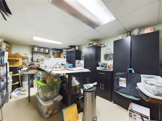 kitchen featuring dark cabinets, a paneled ceiling, light countertops, and light colored carpet