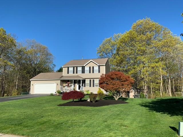 view of front of home featuring a garage, aphalt driveway, and a front yard