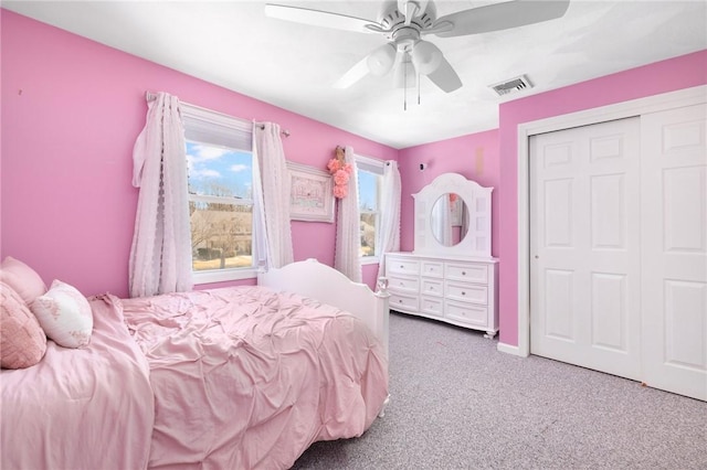 bedroom with carpet, a closet, visible vents, a ceiling fan, and baseboards