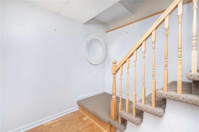 stairway with baseboards and wood finished floors