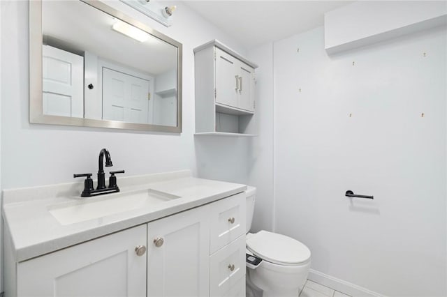 bathroom with toilet, baseboards, and vanity