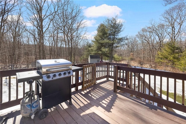 deck featuring a forest view and area for grilling