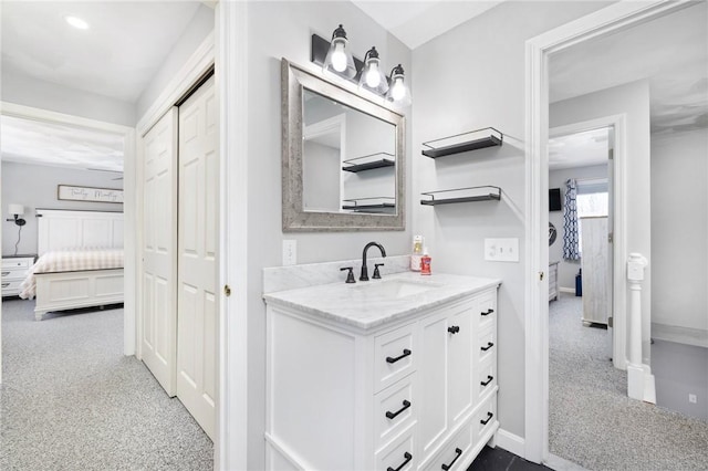 ensuite bathroom featuring ensuite bathroom, vanity, and baseboards