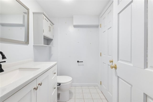 bathroom featuring baseboards, vanity, toilet, and tile patterned floors