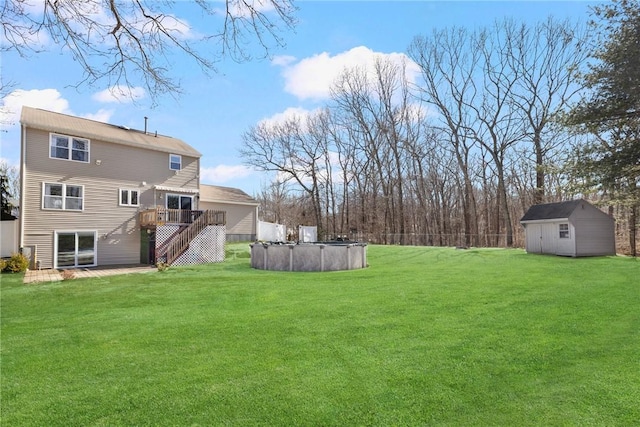 view of yard featuring an outbuilding, a deck, stairway, a covered pool, and a shed