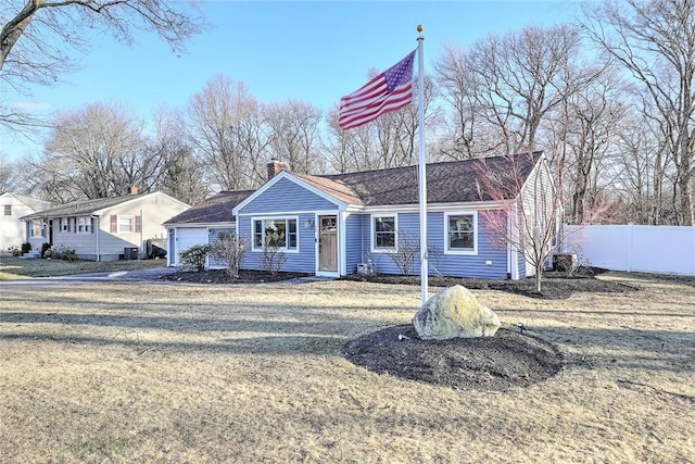 ranch-style house with a garage, a chimney, a front yard, and fence