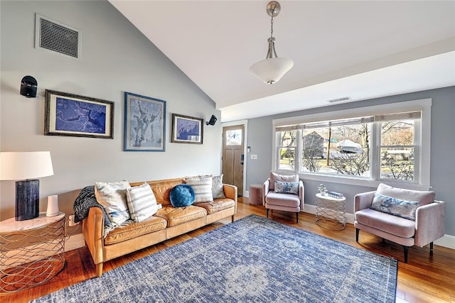 living room featuring wood finished floors, visible vents, and baseboards