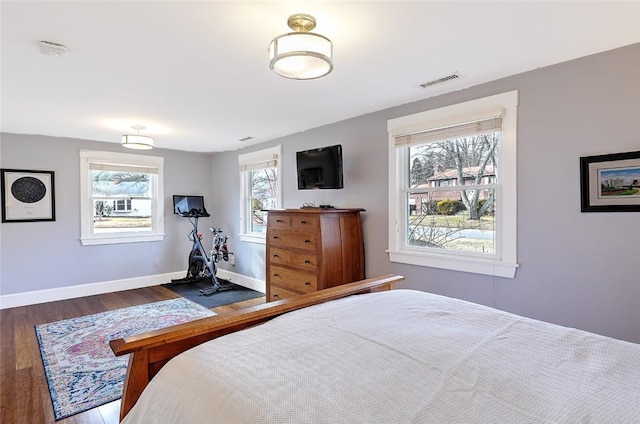 bedroom with dark wood-style flooring, visible vents, and baseboards