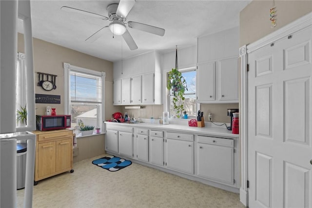 kitchen with a wealth of natural light, white cabinets, and light countertops