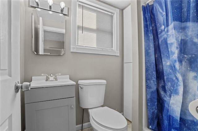 bathroom featuring toilet, a stall shower, and vanity