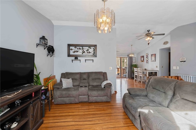 living area featuring light wood-type flooring, lofted ceiling, and ceiling fan with notable chandelier