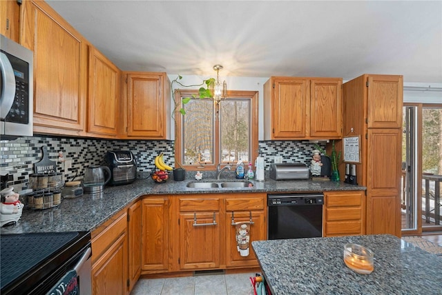 kitchen with light tile patterned floors, stainless steel appliances, a sink, dark stone counters, and tasteful backsplash