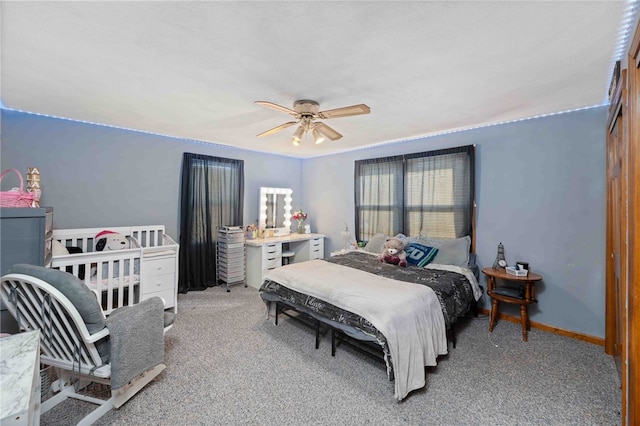 carpeted bedroom with ceiling fan and baseboards