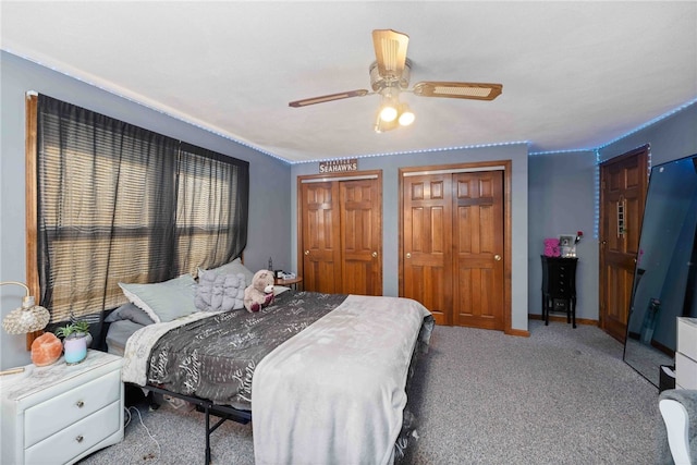 bedroom featuring multiple closets, carpet flooring, baseboards, and a ceiling fan