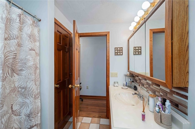 bathroom with tile patterned floors, a shower with curtain, baseboards, and vanity