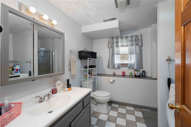 bathroom featuring visible vents, toilet, a shower with shower door, vanity, and tile patterned floors