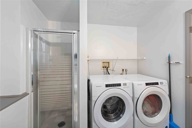 laundry area featuring washer and dryer, laundry area, and a textured ceiling