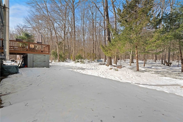 yard covered in snow with a deck and a garage