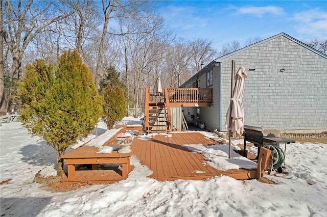 yard covered in snow featuring stairway and a deck