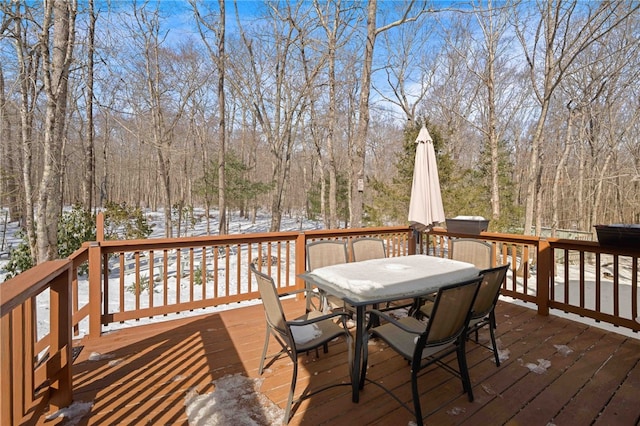 snow covered deck featuring outdoor dining area