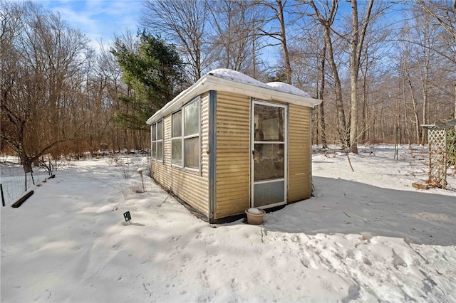 snow covered structure featuring an outbuilding