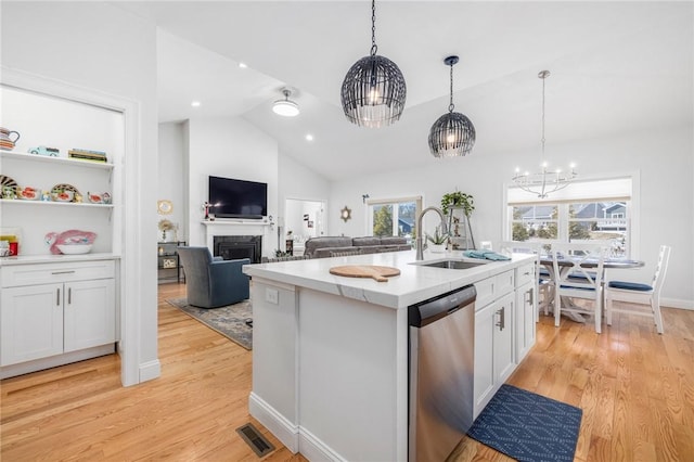 kitchen with a sink, white cabinetry, light countertops, and dishwasher