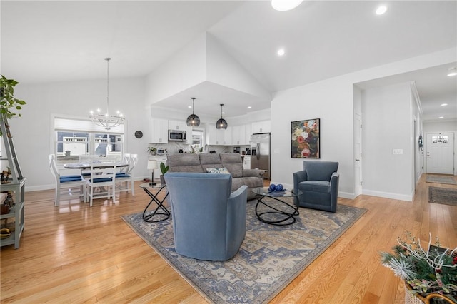 living room with light wood-style floors, baseboards, high vaulted ceiling, and an inviting chandelier