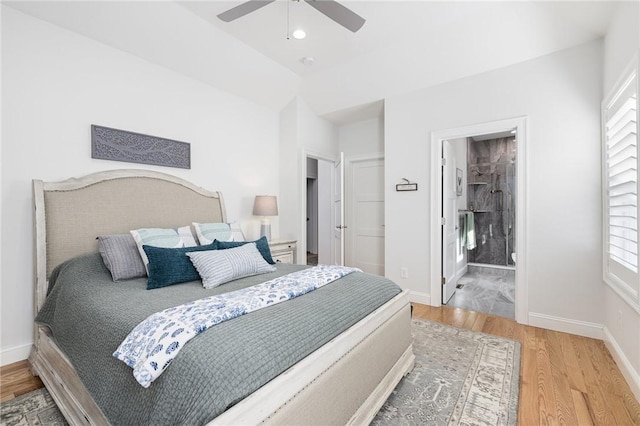 bedroom with a ceiling fan, ensuite bath, baseboards, and wood finished floors