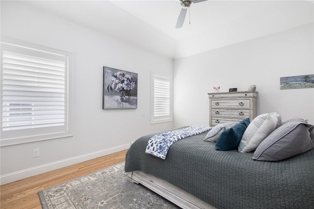 bedroom featuring a ceiling fan, baseboards, and wood finished floors