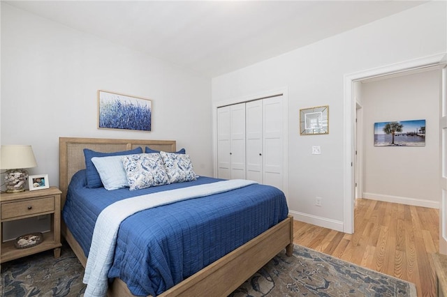 bedroom featuring a closet, baseboards, and wood finished floors