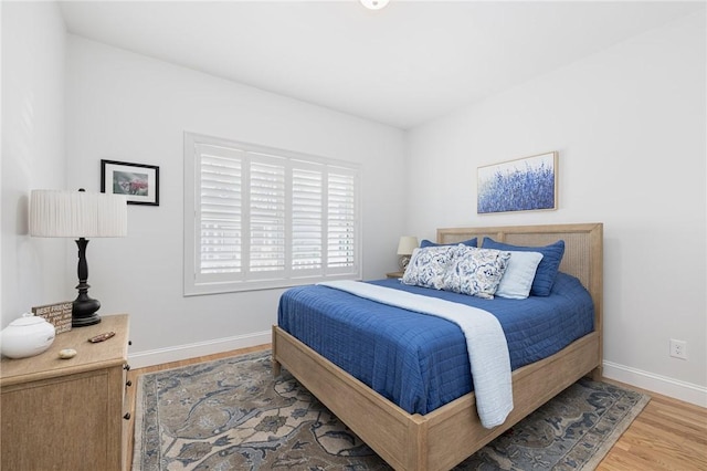 bedroom with baseboards and wood finished floors