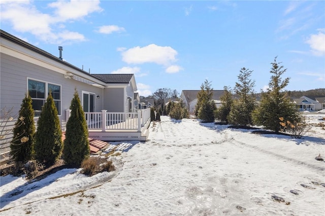 yard layered in snow with a wooden deck