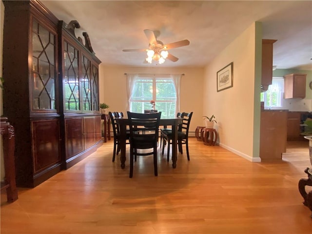 dining area with light wood-type flooring, ceiling fan, and baseboards